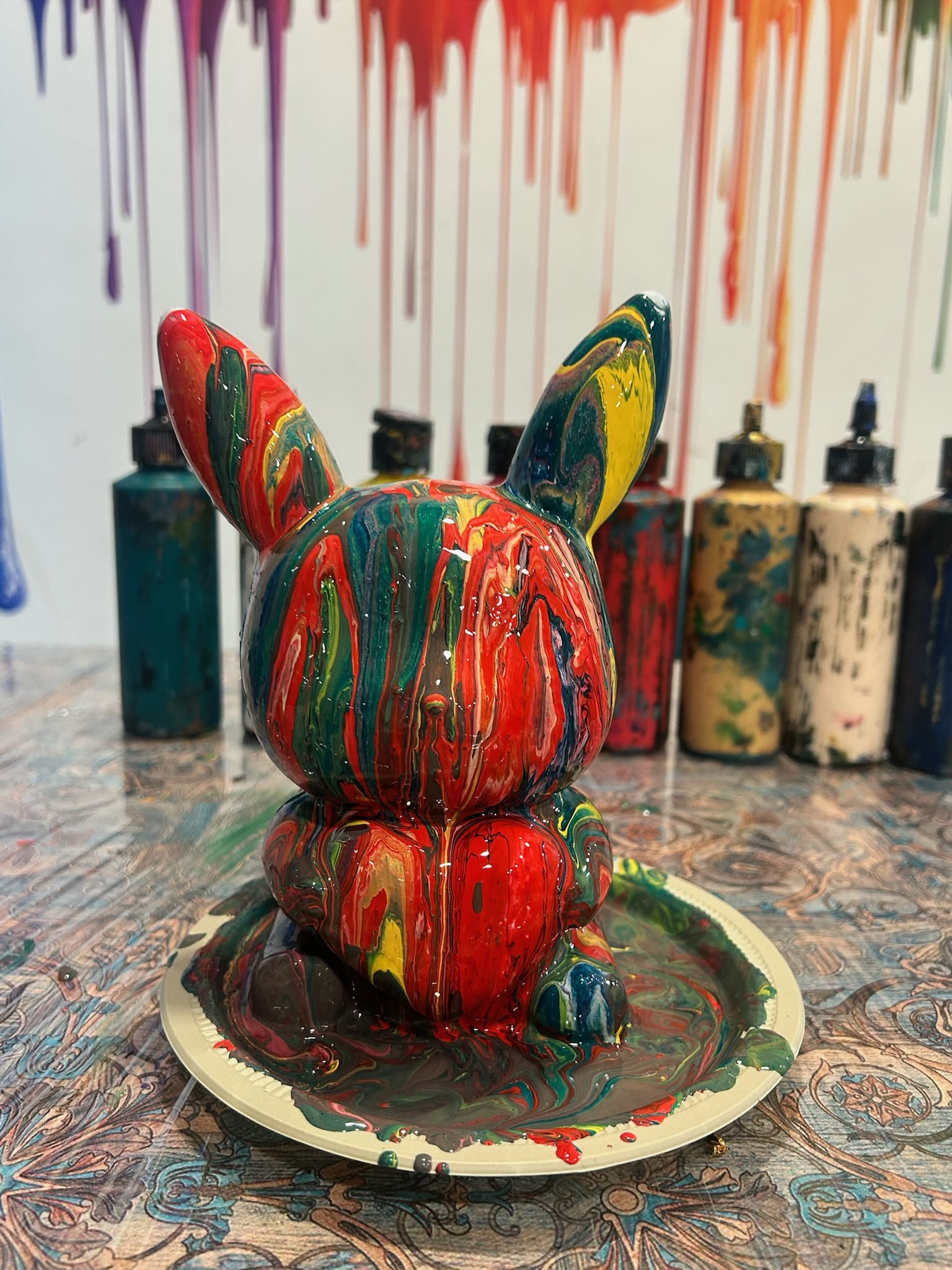 Acrylic paint being poured over a plaster teddy bear at Splashit